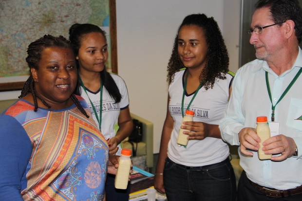 A Secretária, Macaé Evaristo e Superintendente da SRE Sete Lagoa, Arquimedes, receberam uma amostra do iogurte produzido na escola de Prudente de Morais. Foto: Elian Oliveira/ACS-SEE