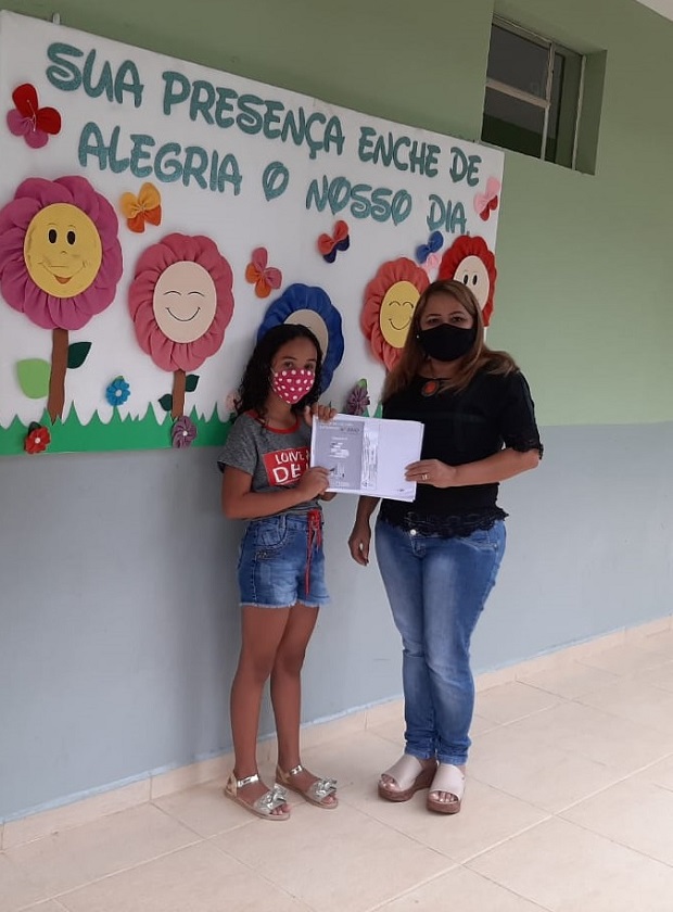Raísa devolvendo o PET para a diretora Rita Soares Mendes, da Escola Estadual Professora Hermínia Pereira de Almeida, na cidade de Ataléia. Foto: Arquivo da Escola